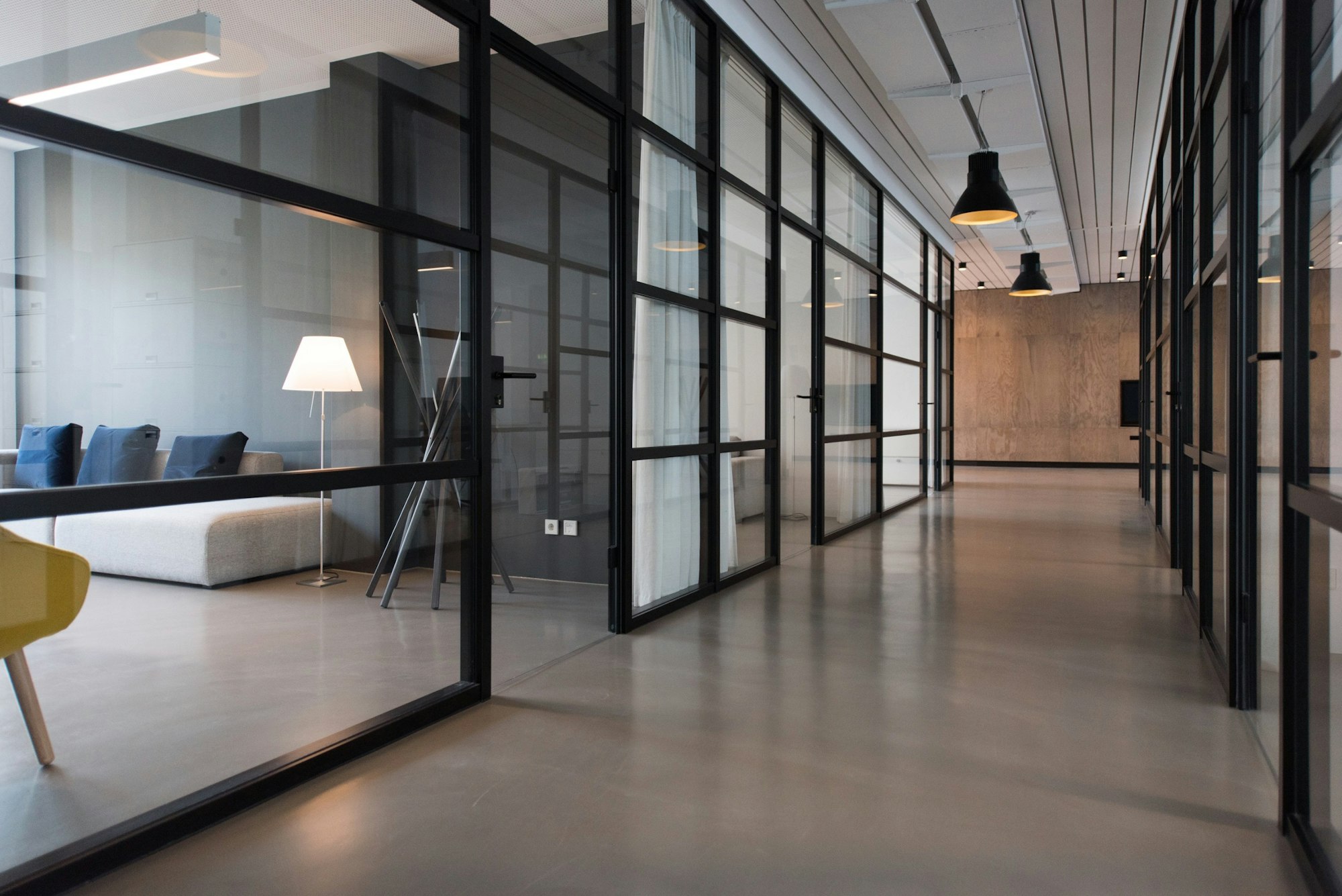 A quiet office corridor with glass meeting rooms
